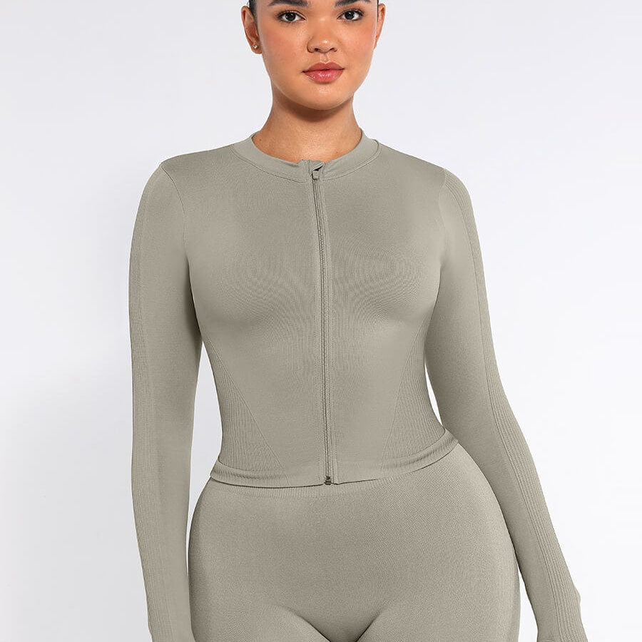 Woman wearing a beige long-sleeve bodysuit on a white background