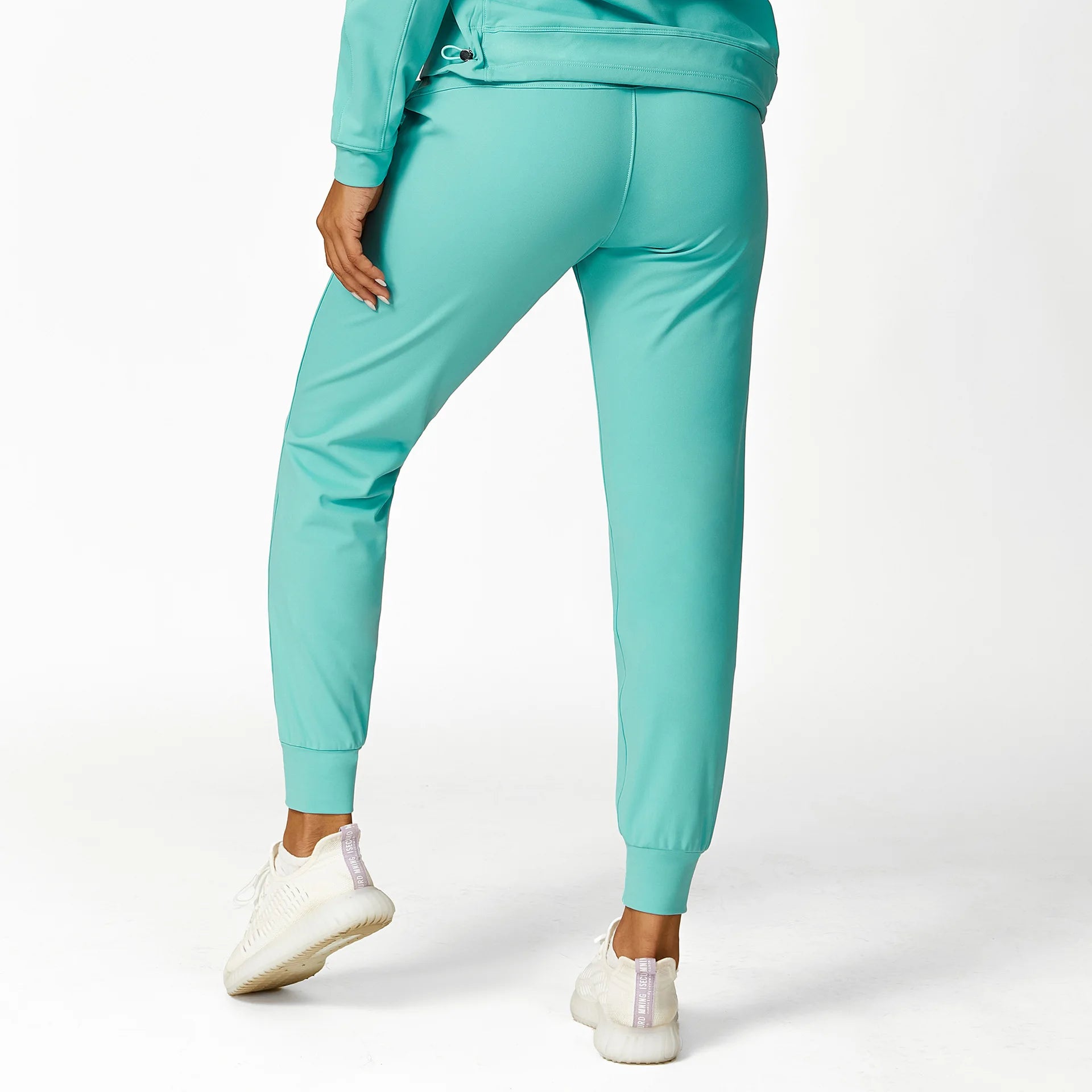 a woman wearing a green sweat suit and white sneakers