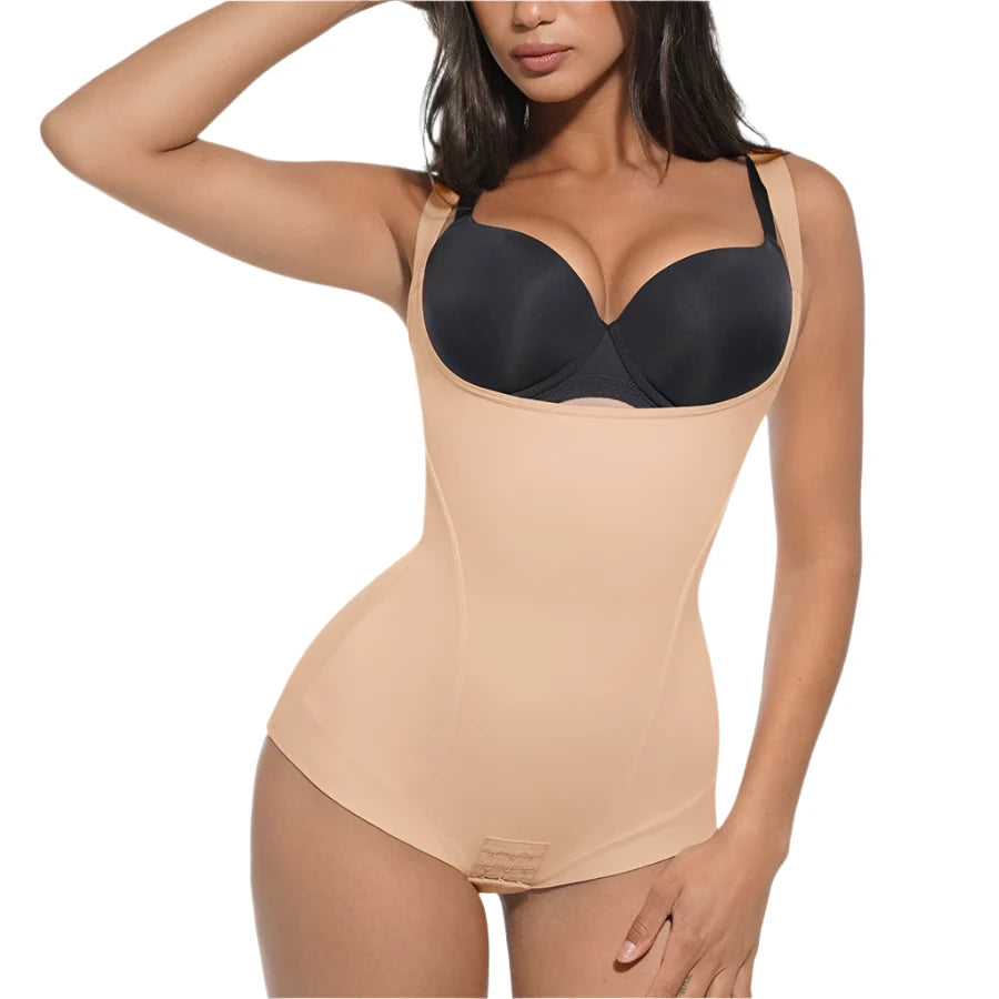 Woman wearing a black bra and beige shapewear on a white background